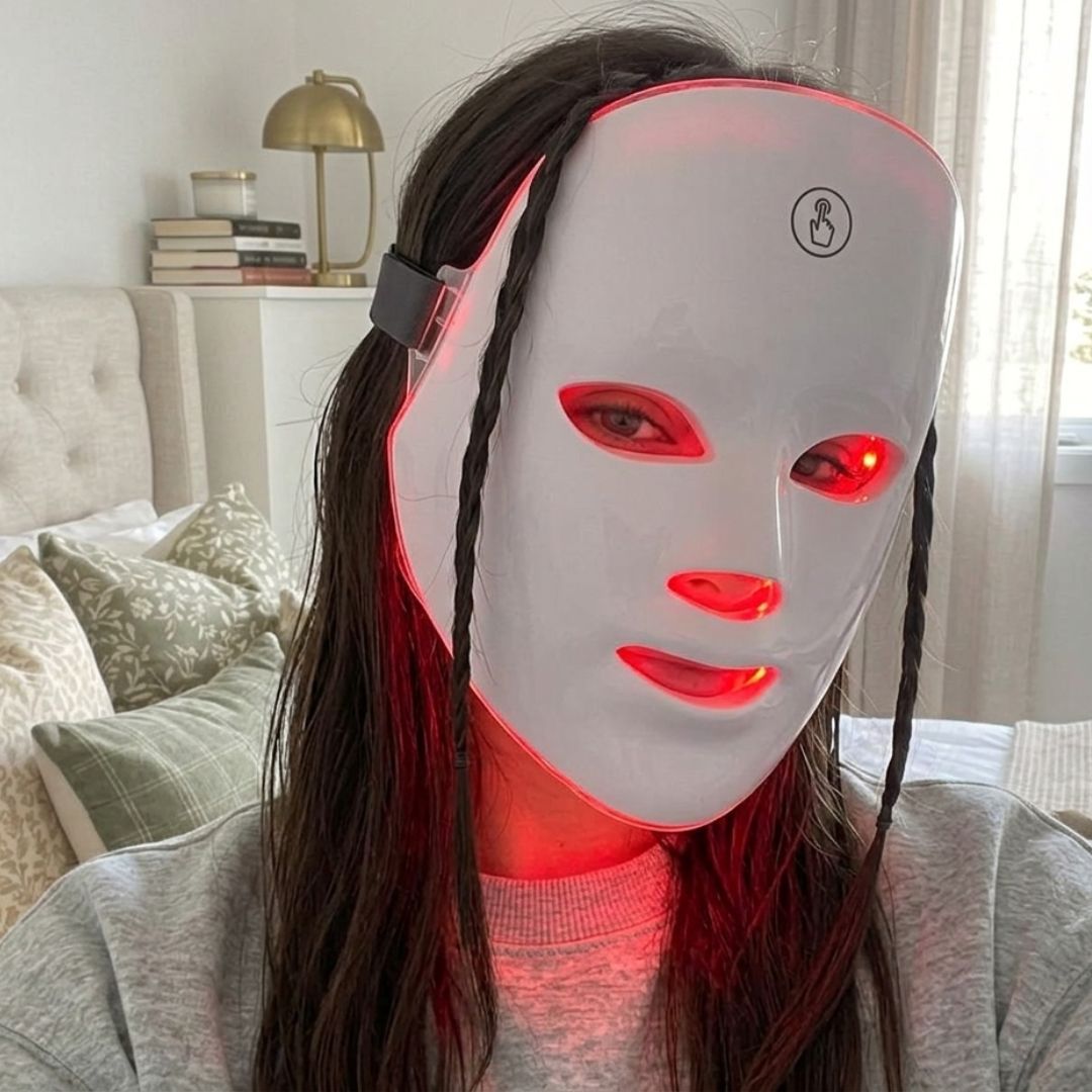 Žena nosi LED masku za lice u spavaćoj sobi